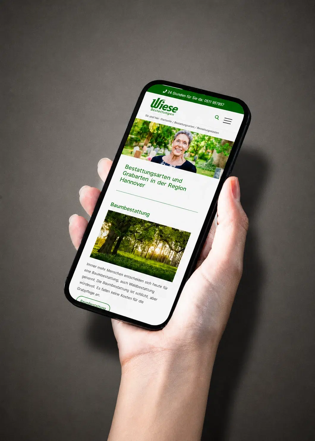 Eine Hand hält ein Smartphone mit der Webseite von Wiese Bestattungen zum Thema Bestattungsarten in Hannover.