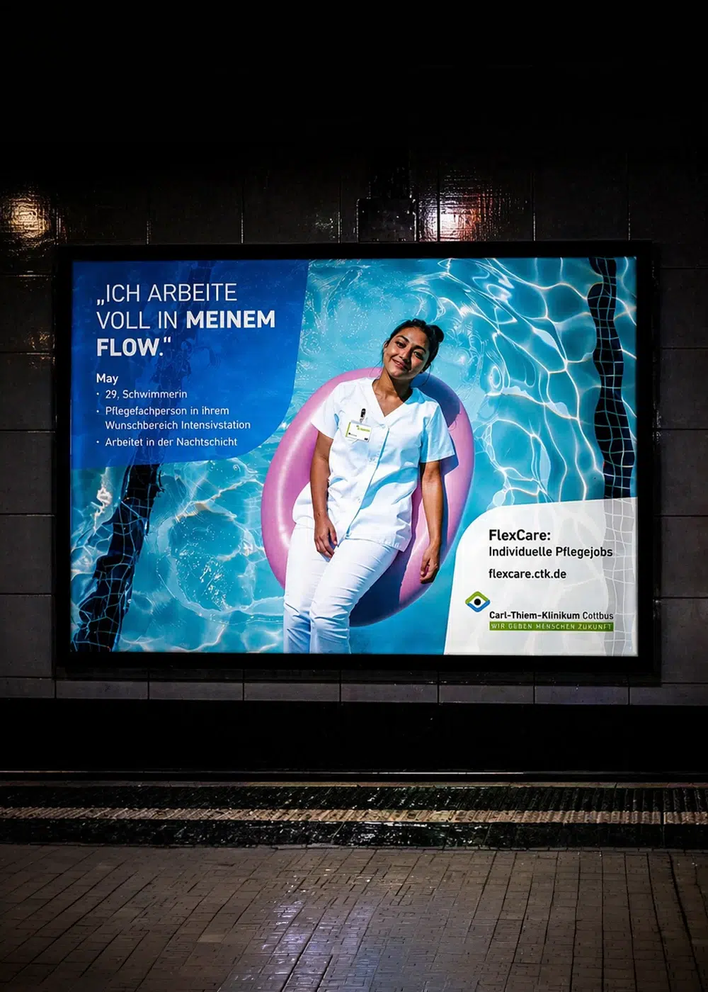 Werbeplakat des Carl-Thiem-Klinikums Cottbus für Pflegejobs mit einer Pflegekraft in Arbeitskleidung, die in einem pinken Schwimmring auf einer Wasserfläche liegt.