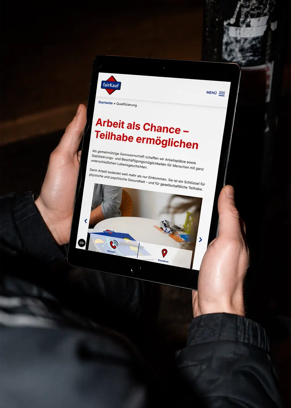 Eine Person hält ein Tablet mit der fairKauf-Webseite und der Überschrift Arbeit als Chance – Teilhabe ermöglichen in den Händen.