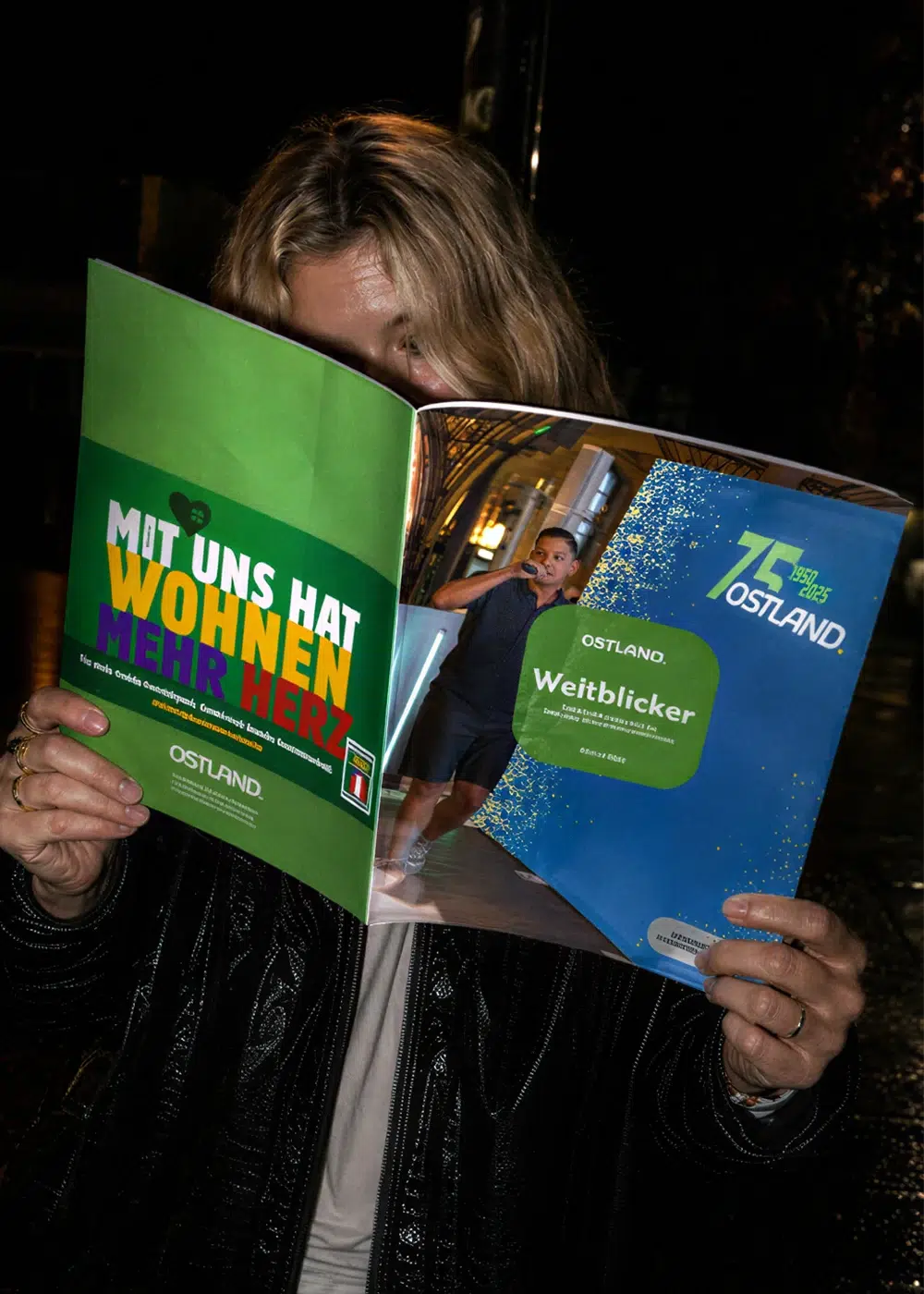 Eine Frau hält das geöffnete Magazin Weitblicker der Wohnungsgenossenschaft Ostland in den Händen.
